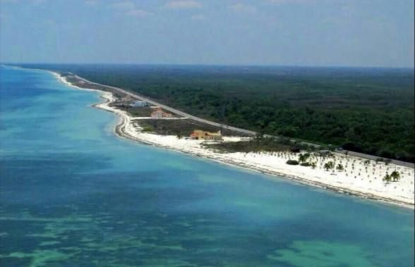 Terreno ecoturístico con playa, arena blanca y clima tropical.